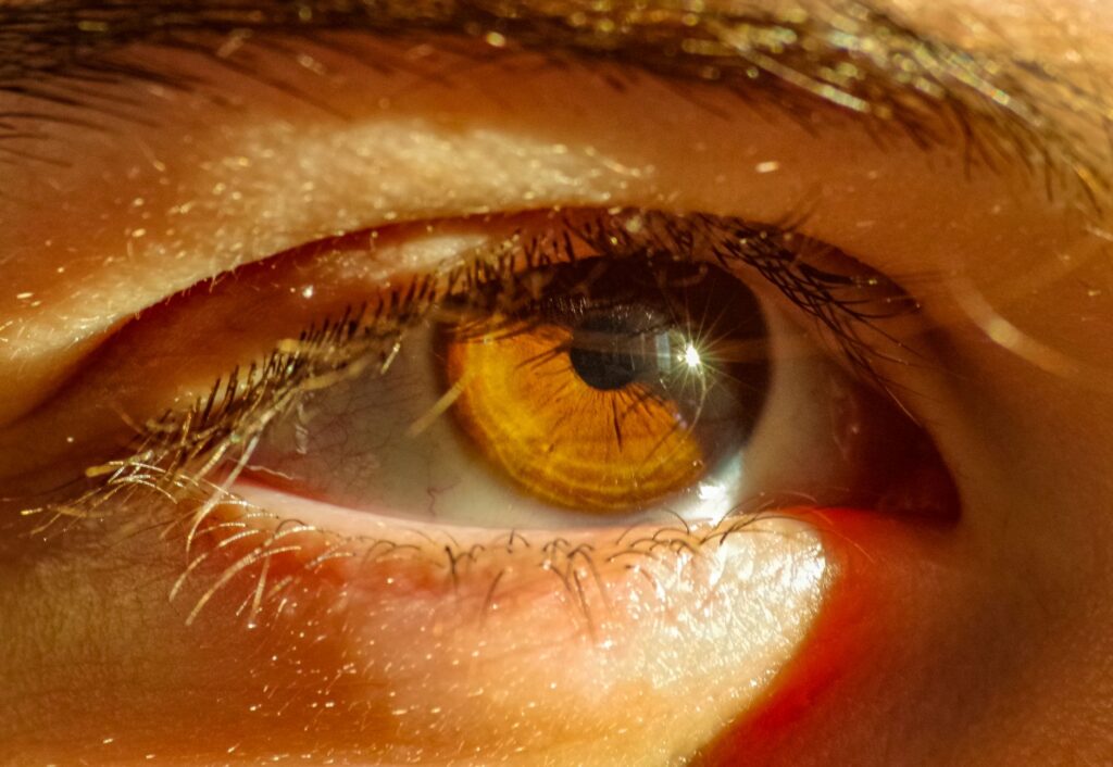Detailed close-up of a human eye reflecting sunlight with vivid colors.