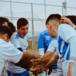 A soccer team gathers in a huddle for motivation before a match, fostering teamwork and unity.