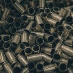 Close-up of a pile of metal bullet casings, emphasizing abundance and metallic texture.