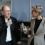 Two business professionals sharing a coffee break in a modern office kitchen.