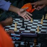 Street chess match in Bali, Indonesia with multiple players involved in a strategic conversation.