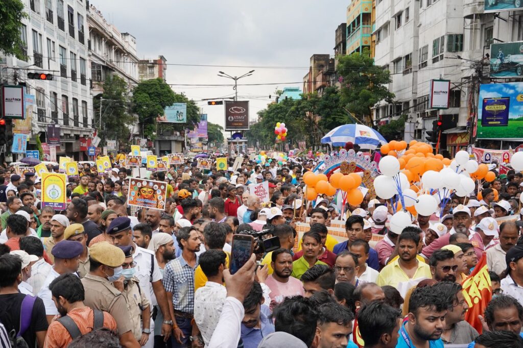 Crowds gather for a colorful street festival in Kolkata, showcasing cultural richness and diversity.