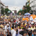 Crowds gather for a colorful street festival in Kolkata, showcasing cultural richness and diversity.
