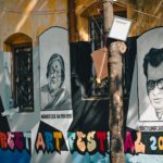 Vibrant street art mural depicting famous figures at a festival in Kolkata, India.