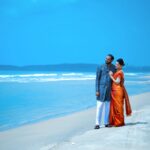 A couple in traditional attire enjoying a serene moment on a Hyderabad beach.