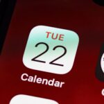 Detailed close-up of an iPhone home screen focused on the calendar app icon.