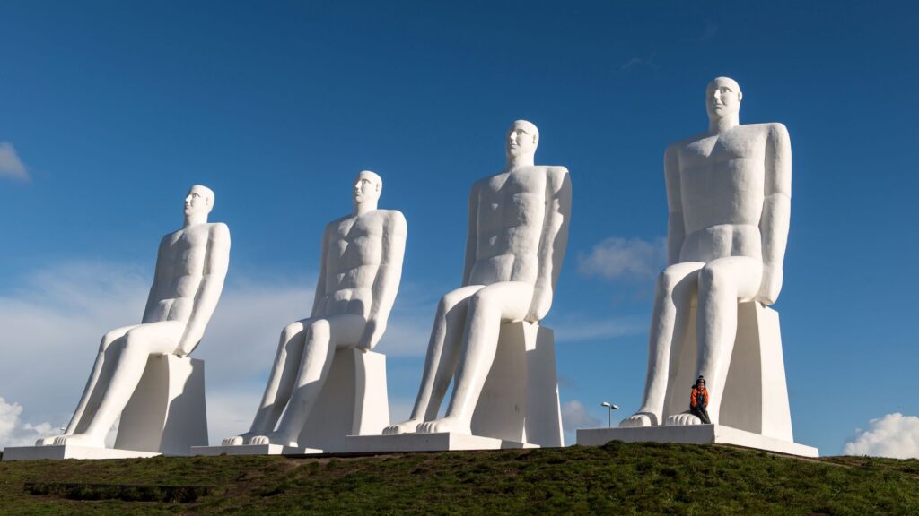 Iconic Man Meets the Sea sculptures under a clear sky in Esbjerg, Denmark.