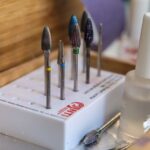 Detailed view of manicure drill bits and polish for nail care.