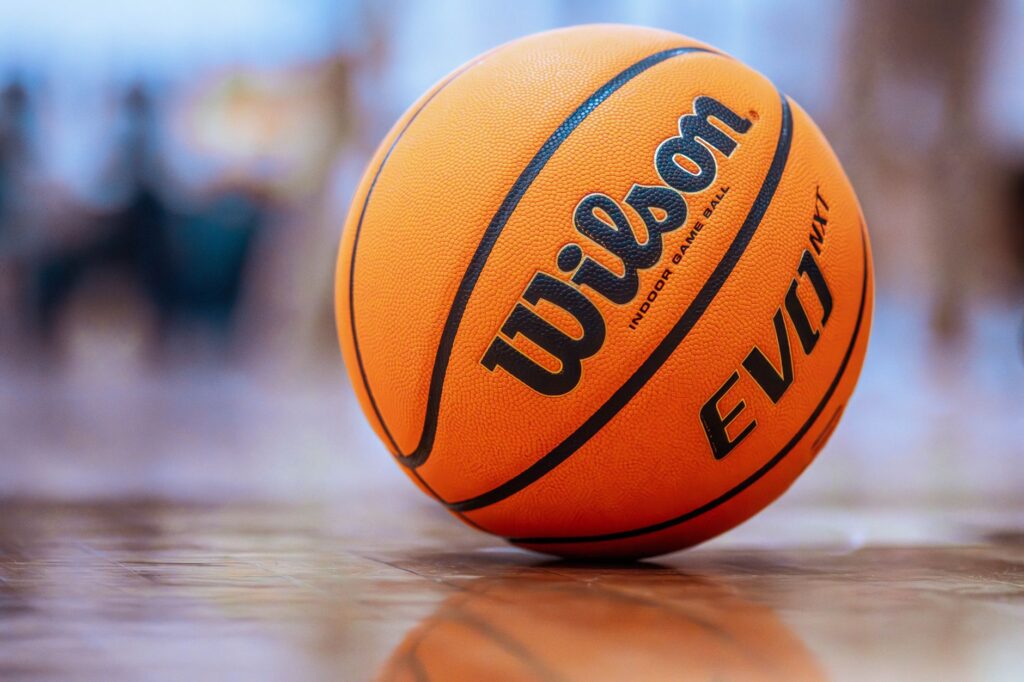 Orange basketball on a polished indoor gym floor, ready for play.