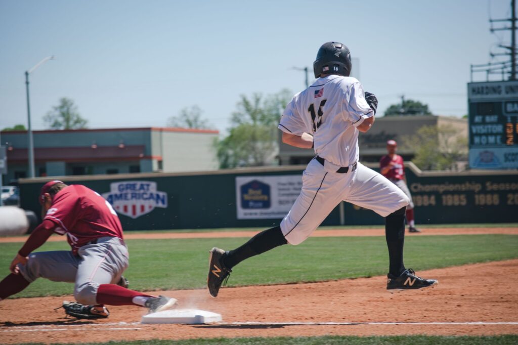 Two baseball players compete in an intense game at Harding University Stadium, showcasing sportsmanship and action.