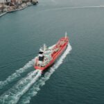 Aerial shot of a red cargo ship navigating the Bosphorus Strait near Istanbul, Turkey.