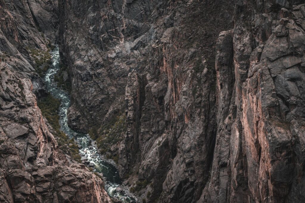 Aerial view of the rugged Black Canyon showcasing dramatic geological formations and a flowing river.