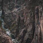 Aerial view of the rugged Black Canyon showcasing dramatic geological formations and a flowing river.