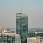 A striking view of a modern skyscraper amidst Gdańsk's cityscape, showcasing urban architecture.