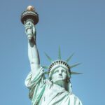 Close-up of the iconic Statue of Liberty against a clear blue sky, symbolizing freedom in New York City.