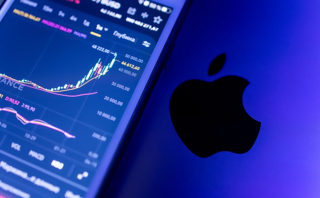 A close-up of an Apple device displaying stock market graphs, indicating economic trends.