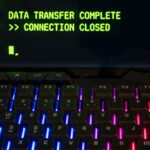 Close-up of a RGB lit keyboard with a screen displaying 'Data Transfer Complete'.