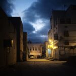 Peaceful evening street scene in Tarim, showing traditional architecture under a cloudy sky.